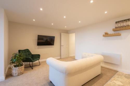 a living room with a white couch and a chair at Apartment 1, King's Court in Scarborough