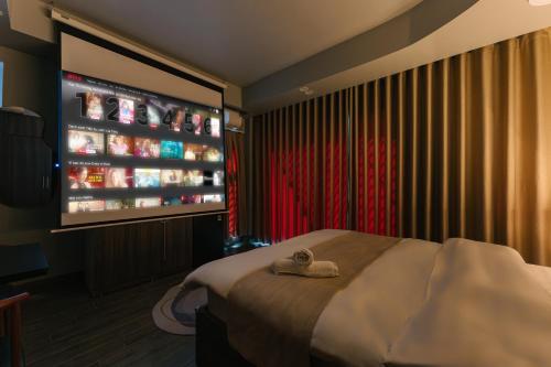a hotel room with a bed and a tv at My Home Westlake Hanoi in Hanoi