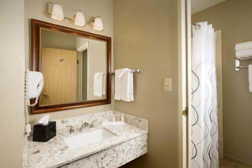 een badkamer met een wastafel en een spiegel bij Redmond Inn in Redmond