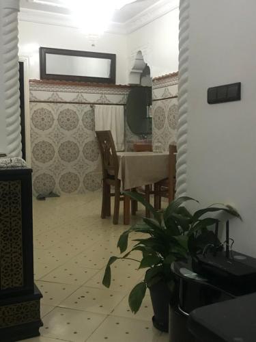 a dining room with a table and a plant at Appartement Familial près Aéroport Tanger in Tangier