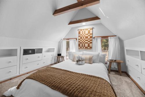ein weißes Schlafzimmer mit einem großen Bett und weißen Schränken in der Unterkunft Big Bear Mountain Retreat with Hot Tub by MariamsBnb in Big Bear City Airport