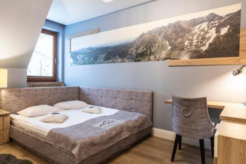 a bedroom with a bed and a painting on the wall at TatryTop Zakopiańskie Tarasy Premium & SPA in Zakopane