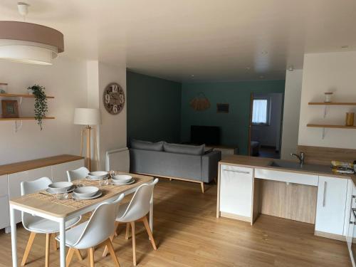 een keuken en woonkamer met een tafel en stoelen bij Appartement 15 min Disney Paris in Coutevroult