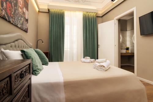 a bedroom with a large bed with towels on it at Archimedes suites in Catania