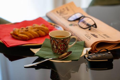 a table with a cup of coffee and a book at Archimedes suites in Catania