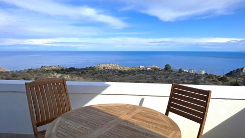 a table and chairs on a balcony with the ocean at Villa Dragonfly in Kefalás