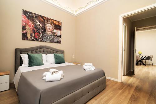 a bedroom with a large bed with towels on it at Archimedes suites in Catania