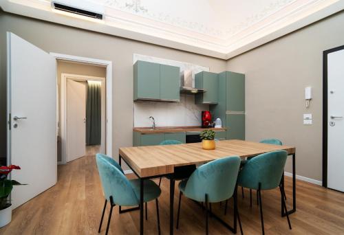 a kitchen and dining room with a wooden table and blue chairs at Archimedes suites in Catania