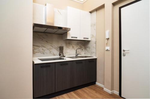 a kitchen with white cabinets and a sink at Archimedes suites in Catania