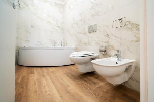 a bathroom with a tub and a toilet and a sink at Archimedes suites in Catania