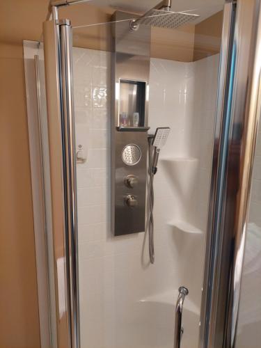 a shower with a glass door in a bathroom at Studio-hôtel Villegiature Saint-Sauveur in Piedmont