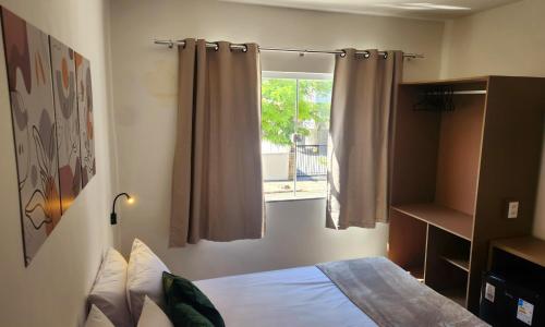 a bedroom with a bed and a window at Pousada Noa in Cabo Frio