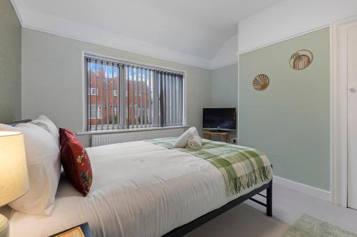 a white bedroom with a bed and a window at Pass the Keys Lovely Home in York with Parking in York