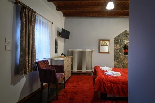a bedroom with a bed and a table and chairs at Konaki inn in Palaios Agios Athanasios