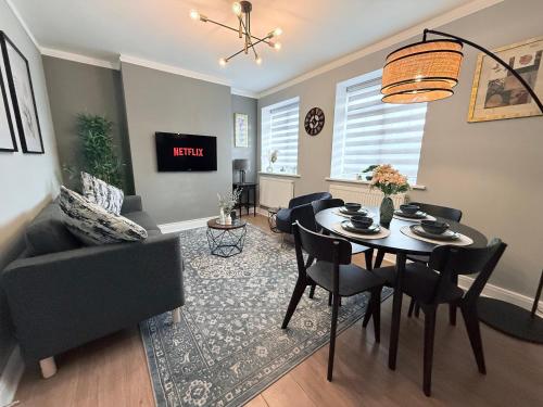 ein Wohnzimmer mit einem Tisch und einem Sofa in der Unterkunft StayLondon - Sleeps 5 with Free Parking - best for Holiday, Concerts or Matches in London