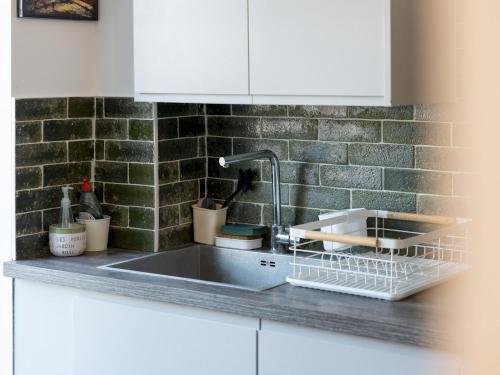 a kitchen sink with a dish rack next to it at Pass the Keys Stylish Family Friendly 3 Bed Home in Borehamwood in Borehamwood