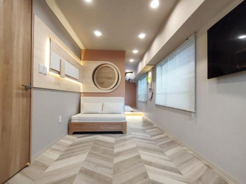 a hallway with a white chair and a tv at 26 新宿中心2卧室 超级商圈 交通枢纽 早稻田大学 东新宿车站8分钟 最大5人 Shinjuku center 8 mins to ST 5P Maxs 直达新宿 涉谷 表参道 品川 池袋 上野 代代木 银座 原宿 in Tokyo