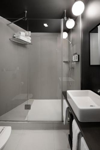 a bathroom with a glass shower and a sink at Wilson Boutique Hotel in Barcelona