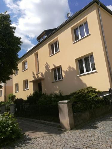 a yellow house with a fence in front of it at Zum-Rudi in Halberstadt