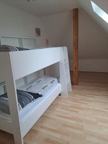 a white bunk bed in a room with a wooden floor at Zum-Rudi in Halberstadt