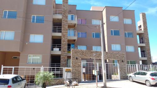 a tall building with cars parked in front of it at Coral de Madryn in Puerto Madryn