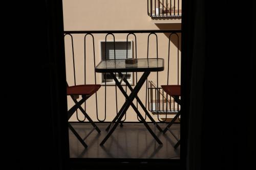a small table on a balcony with two chairs at Le Corti del Re in Naples