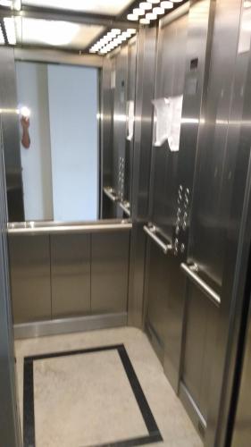 a bathroom with stainless steel walls and a mirror at Coral de Madryn in Puerto Madryn