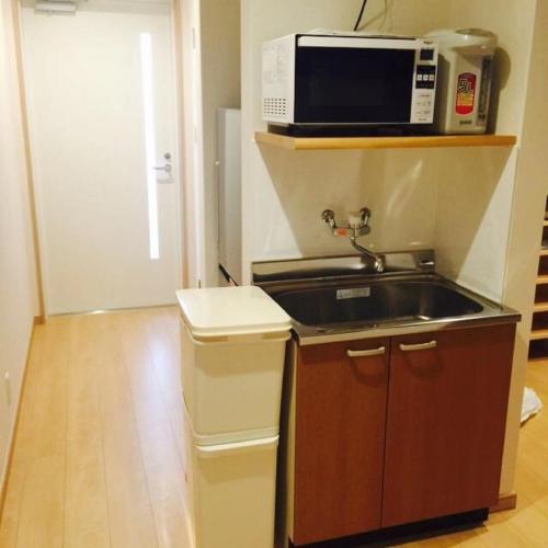 a kitchen with a sink and a microwave at あり宿 USJ&万博 大阪西九条駅 Ariyado USJ&EXPO Osaka Nishikujo in Osaka