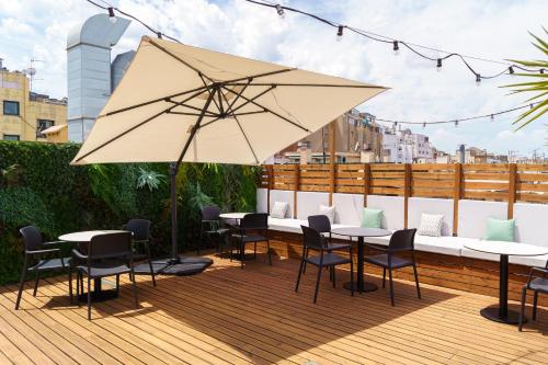 a patio with tables and chairs and an umbrella at Casa Lit Barcelona in Barcelona