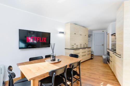 a kitchen and dining room with a wooden table and chairs at Esclusivo trilocale 6 posti letto sulle piste da sci in Breuil