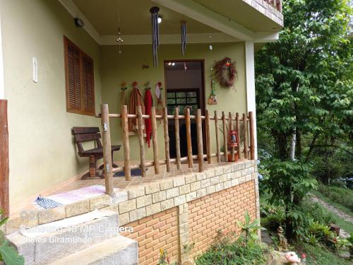 una casa con recinzione e tavole da surf su un portico di Chalés Giramundo a Visconde De Maua