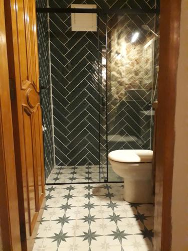 a bathroom with a toilet and a tiled floor at Tahtavilla Pansiyon in Cıralı