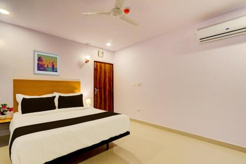 a bedroom with a bed and a ceiling fan at Super townhouse Dilshuk Nagar in Hyderabad