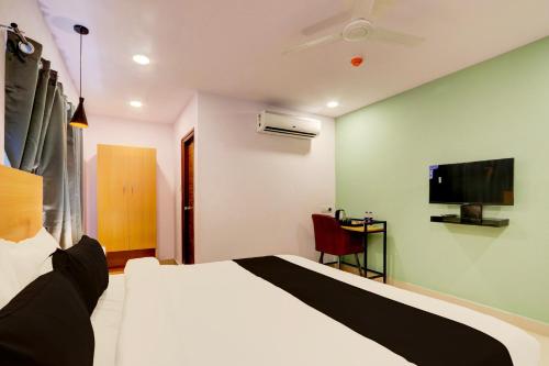 a hotel room with a bed and a tv at Super townhouse Dilshuk Nagar in Hyderabad