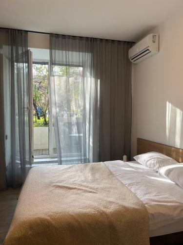a bedroom with a large bed and a large window at МІАМО студіо з терасою in Lviv