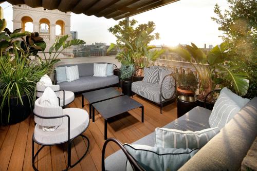 a patio with couches and chairs on a balcony at Wilson Boutique Hotel in Barcelona