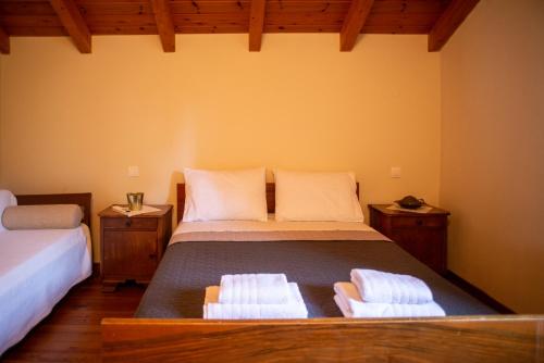 Agnes Cottage House في كونيتسا: غرفة نوم بها سرير عليه منشفتان