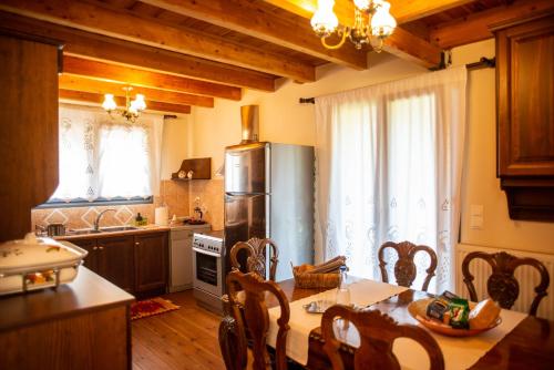 Agnes Cottage House في كونيتسا: مطبخ مع طاولة وكراسي ومطبخ مع مطبخ