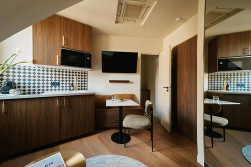 une cuisine avec des armoires en bois et une table et des chaises dans l'établissement Lavie Maison - 33 Louvre, à Paris