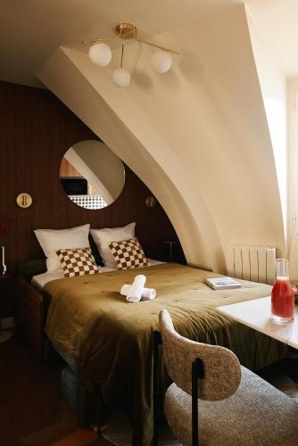 une chambre avec un lit, une chaise et un miroir dans l'établissement Lavie Maison - 33 Louvre, à Paris