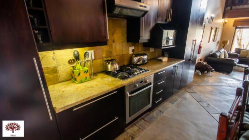 a kitchen with a stove and a counter top at Zebula Golf and Wildlife Estate - Jackals Call Pax 8 - Moi Signature Luxury villa in Mabula