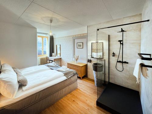 a bedroom with a bed and a shower in it at DU GLACIER Boutique & Traditions Hotel in Fiesch