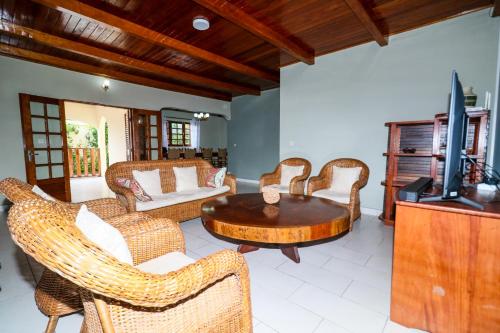 a living room with wicker chairs and a wooden table at Villa Nath - Kribi in Elabi