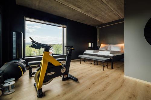 a room with a gym with a bed and a treadmill at Comfort Hotel Porsgrunn in Porsgrunn