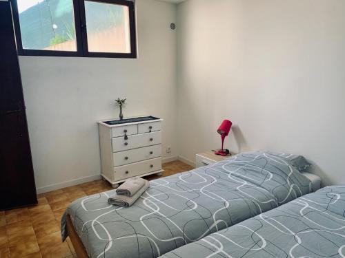 - une chambre avec un lit et une commode avec une lampe dans l'établissement 3P 65 m2 au calme colline de Cagnes sur Mer, à Cagnes-sur-Mer