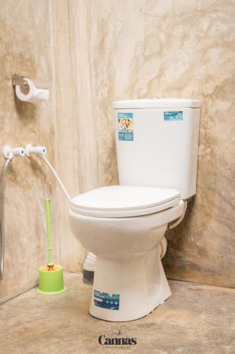 a white toilet in a bathroom with a shower at Cannas Hiri in Dickwella