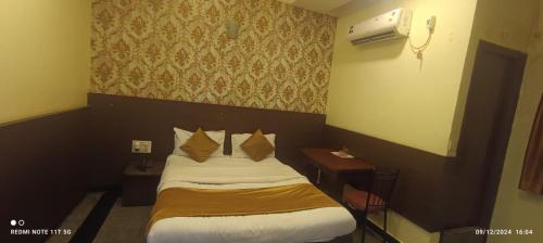 a hotel room with a bed and two pillows at Hotel nav bharath residency in Hyderabad