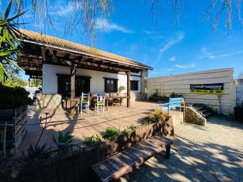 a pavilion with a table and chairs and a bench at Kite Holiday House Tarifa in Tarifa