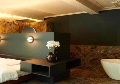 a bedroom with a bed and a table with flowers on it at Nonam Boutique Hotel Gent in Ghent