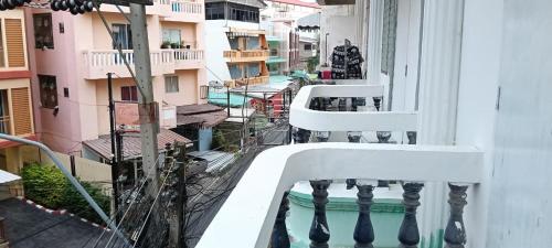 a balcony of a building with a white railing at Marine Guest House Encore in Pattaya South